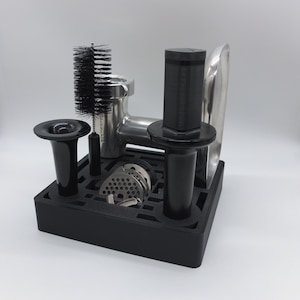 May include: A black plastic stand with a variety of attachments for a meat grinder. The stand includes a brush, a metal grinder, and a variety of metal plates.