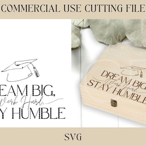 May include: A light-colored wooden box with a hinged lid, engraved with the words "DREAM BIG, Work Hard, STAY HUMBLE" and a graduation cap illustration. The image also includes the text "COMMERCIAL USE CUTTING FILE" and "SVG".