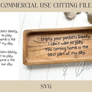 May include: A wooden tray with the text "Empty your pockets Daddy, I can't wait to play. You coming home is the best part of my day." engraved on it. The tray is a light brown colour and has a rectangular shape.