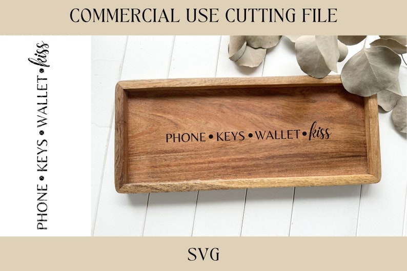 May include: A wooden tray with the text "PHONE &bull; KEYS &bull; WALLET &bull; kiss" engraved on it. The tray is on a white surface.