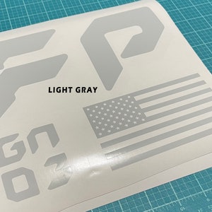 May include: A sheet of light gray vinyl decal stickers featuring the letters "GO", the number "3", and two different shapes of the letter "F". The sheet also includes a small American flag.