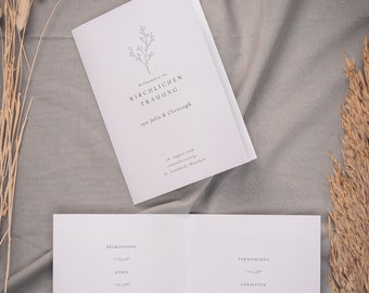 Può includere: Un programma di cerimonia nuziale bianco con un semplice design floreale e il testo "Willkommen zur Kirchlichen Trauung von Julia & Christoph" sulla copertina. Il programma elenca l'ordine della cerimonia, tra cui il saluto, il Kyrie, il Tagesgebet, il Traupredigt, la Befragung des Brautpaares, la Segnung der Ringe, il Forbitten, il Vater Unser, il Schlusssegen e l'Auszug.