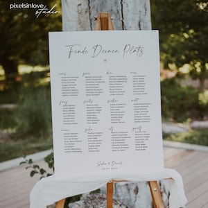 May include: A white sign with black text on an easel. The sign says "Finde Deinen Platz" which translates to "Find Your Seat" in English. The sign lists names in different categories, such as "eins", "zwei", "drei", "vier", "f&uuml;nf", "sechs", "sieben", "acht", "neun", "zehn", "elf", and "zw&ouml;lf". The sign is decorated with a heart and the date "20-07-20XX".