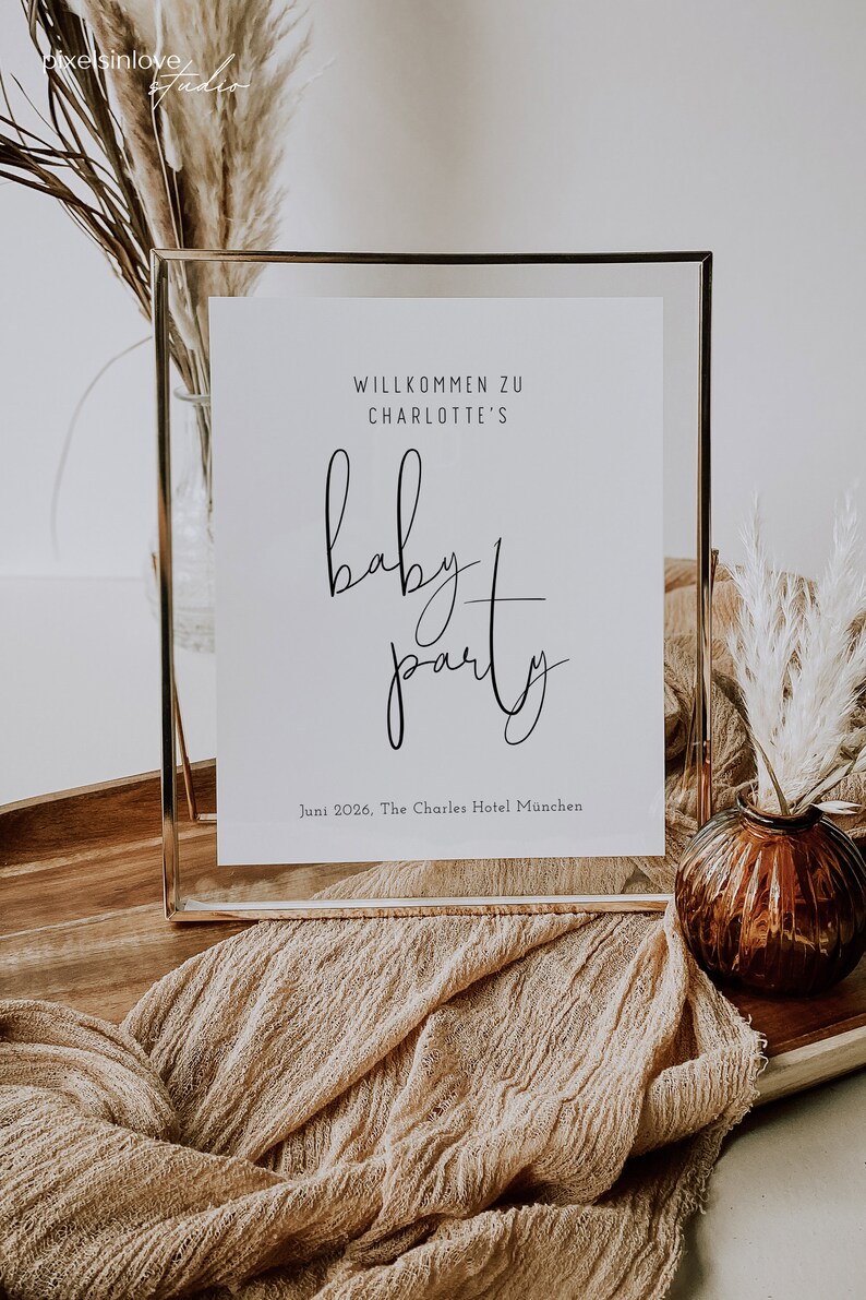 Puede incluir: Un cartel enmarcado en dorado con el texto "Willkommen zu Charlotte's Baby Party" y la fecha "Juni 2026, The Charles Hotel Munchen".