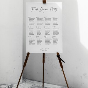 May include: A white seating chart with the title "Finde Deinen Platz" and a heart symbol. The chart lists names in German under the numbers one through eleven.
