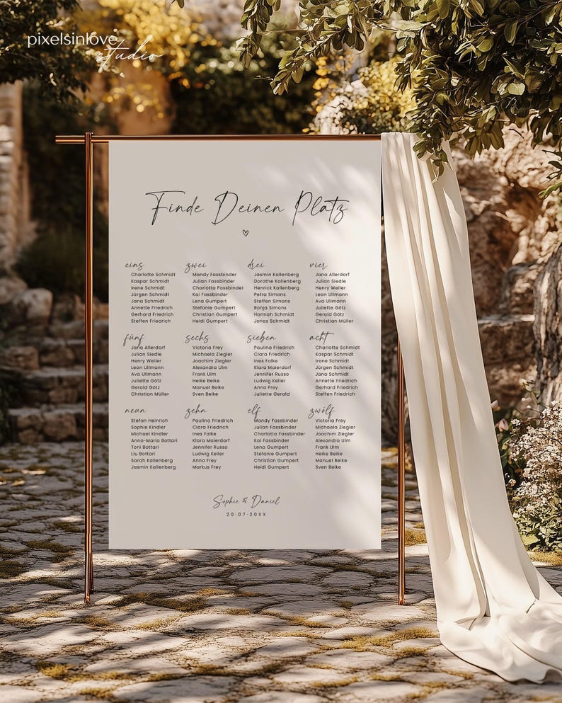 May include: A white sign with black text that reads "Finde Deinen Platz" (Find Your Seat) with a heart symbol. The sign is divided into 12 sections, each with a number and a list of names. The sign is on a wooden stand.
