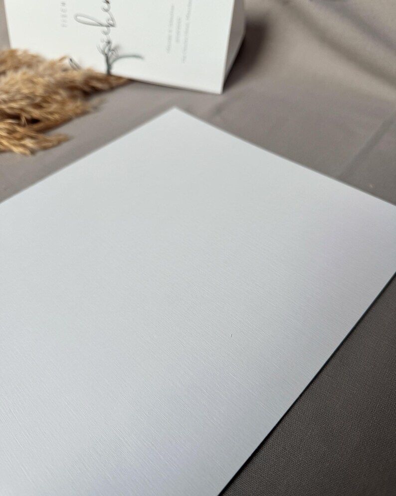 May include: A white textured sheet of paper. The paper has a subtle, fine grain texture.
