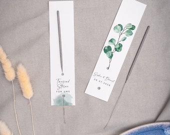 Op de afbeelding: Twee witte kaarten met zilveren sterretjes eraan bevestigd. De kaart links heeft een aquarel achtergrond en de tekst "Tausend Sterne for uns". De kaart rechts heeft een aquarel illustratie van eucalyptus bladeren en de tekst "Sophie & Daniel 20.07.2028".
