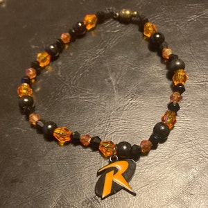 Pulsera R 443 naranja y negra hecha a mano