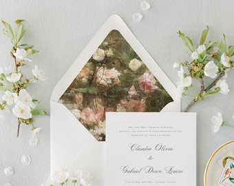 May include: A white wedding invitation card with black serif text reading Claudia Olivia to Gabriel Dean Louise, placed inside an envelope with a floral patterned liner featuring pink and white roses, surrounded by white cherry blossom branches.