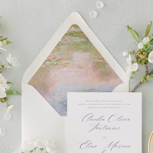Könnte beinhalten: Ein weißer Umschlag mit einem Aquarellbild von Seerosen auf der Klappe. Der Umschlag ist an Claudia Olivia Fontaine und Elias Moreau für ihre Hochzeit adressiert.