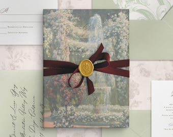 May include: A rectangular wedding invitation card featuring a printed garden fountain scene, wrapped in a deep burgundy velvet ribbon secured with a gold wax seal. The set includes matching sage green envelopes and white RSVP cards with black cursive text.