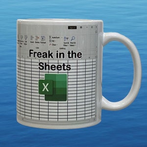 May include: A white ceramic mug featuring a printed graphic of a Microsoft Excel spreadsheet interface. The text "Freak in the Sheets" is displayed in black font above the green Excel logo, which is centered over the grid of spreadsheet cells.