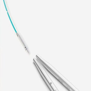 May include: A pair of silver knitting needles with a turquoise cable. The needles are labeled "Exhale" and "Light 5.0mm".