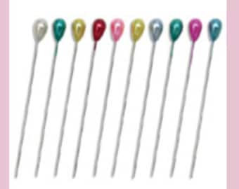May include: Assortment of ten pearl-headed sewing pins in various colors, including gold, red, pink, teal, and silver.