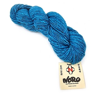 Peut inclure: Une pelote de fil bleu sarcelle avec une étiquette qui indique "Noro the World of Nature Made in Japan".