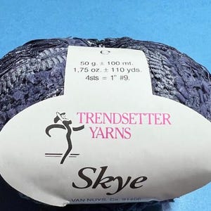 May include: A skein of dark blue yarn labeled "Skye" by Trendsetter Yarns. The label also includes the weight, length, and gauge of the yarn.