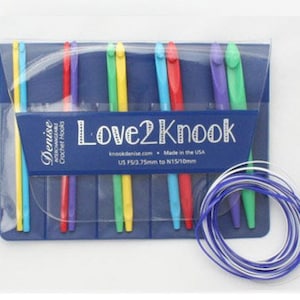 Op de afbeelding: Een set kleurrijke verwisselbare haaknaalden in een blauwe doos met de tekst "Love2Knook" en "US 15/3.75mm tot N15/10mm".