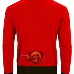 May include: A red long-sleeved sweater with a black collar, cuffs, and hem. The back of the sweater features a logo with a stylized flame and the words "SPINE SPARK". The sweater is made of a ribbed knit fabric.
