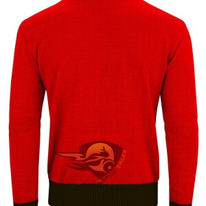 May include: A red sweater with a black collar, cuffs, and hem. The back of the sweater features a logo with a flame design and the text "SPINE SPARK". The sweater has long sleeves and a ribbed texture.
