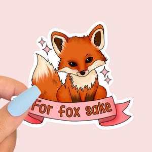 Peut inclure: Un autocollant représentant un renard de dessin animé avec une bannière rose qui dit "For fox sake".