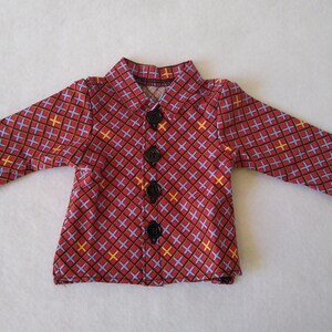 May include: A red, blue and yellow patterned button-up shirt with black buttons.