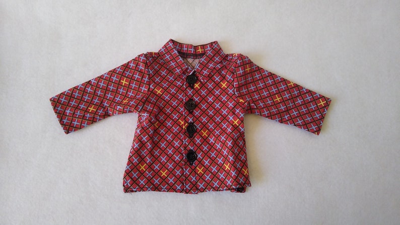 May include: A red, blue and yellow patterned button-up shirt with black buttons.