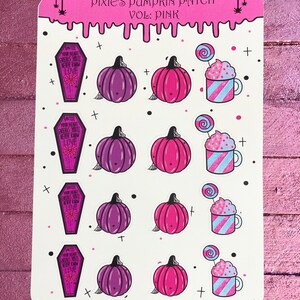 Puede incluir: Una hoja de pegatinas con un diseño de calabaza rosa y morada, un ataúd con el texto "Until your heart breaks you'll never know love", y una taza rosa y azul con crema batida y una piruleta. El texto "Pixie's Pumpkin Patch Vol: Pink" está en la parte superior de la hoja.