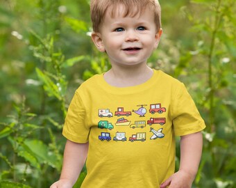 May include: A young child wearing a yellow t-shirt with a colourful print of various vehicles, including a bus, a car, a truck, a helicopter, and an aeroplane. The child is standing in a grassy area.