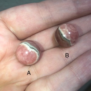 May include: Two pink and white striped spheres with a darker grey band. The spheres are labeled A and B.