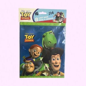Puede incluir: Un paquete de 8 bolsas de regalo de Toy Story con fondo azul e ilustraciones de Buzz Lightyear, Woody, Jessie y Rex. La tarjeta superior muestra el logotipo de Toy Story, el texto 8 LOOT BAGS y una peque&ntilde;a imagen de Buzz Lightyear.