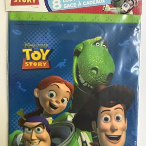 Puede incluir: Un paquete de 8 bolsas de regalo de Disney Pixar Toy Story con Buzz Lightyear, Woody, Jessie y Rex. La tarjeta superior muestra el logotipo de Toy Story, el personaje Buzz Lightyear y el texto 8 LOOT BAGS SACS &Agrave; CADEAUX con precios escritos a mano.