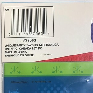 Puede incluir: Una tarjeta de embalaje de producto con un c&oacute;digo de barras, el n&uacute;mero 27563 y el texto UNIQUE PARTY FAVORS, MISSISSAUGA ONTARIO, CANADA L5T 2V7, MADE IN CHINA, FABRIQU&Eacute; EN CHINE. Debajo, un borde verde con iconos de estrellas sobre una secci&oacute;n azul.