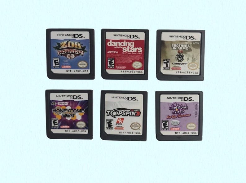 Op de afbeelding: Zes Nintendo DS-gamecartridges worden getoond. Titels zijn onder meer "Zoo Hospital", "Dancing with the Stars", "Brothers in Arms DS", "Honeycomb Beat", "Top Spin" en "The Cheetah Girls". De cartridges hebben kleurrijke game-afbeeldingen.