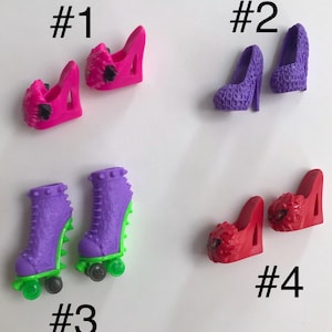 May include: Four pairs of miniature doll shoes labeled #1 through #4. Pair #1 is bright pink wedges. Pair #2 is purple textured pumps. Pair #3 is purple roller skates with green accents. Pair #4 is red wedges with black graphic details on the toes.
