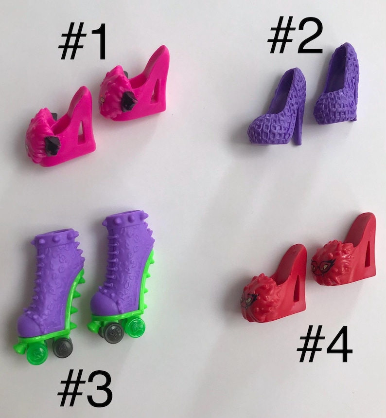 May include: Four pairs of miniature doll shoes labeled #1 through #4. Pair #1 is bright pink wedges. Pair #2 is purple textured pumps. Pair #3 is purple roller skates with green accents. Pair #4 is red wedges with black graphic details on the toes.