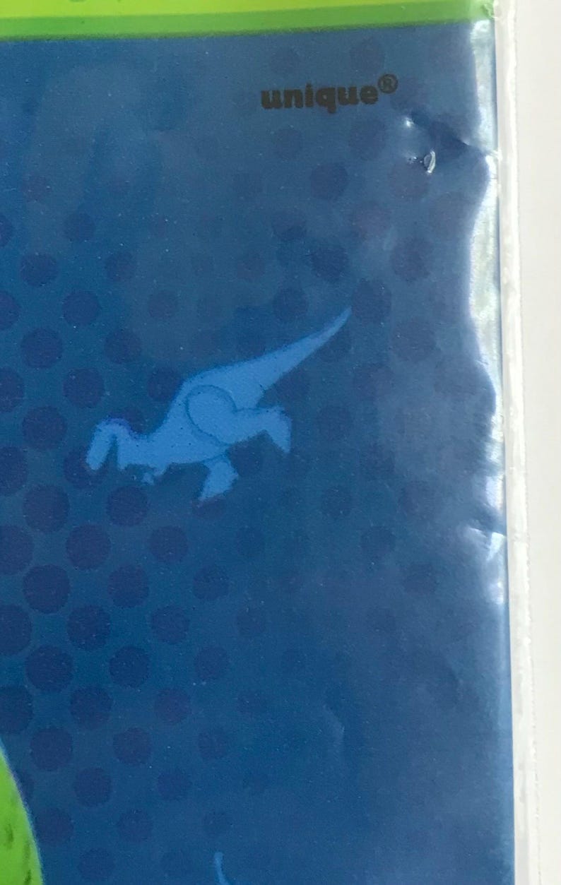 Puede incluir: Una superficie rectangular azul con un patr&oacute;n de puntos azul oscuro y una silueta de dinosaurio azul claro. La palabra unique est&aacute; impresa en letras peque&ntilde;as y oscuras cerca del borde superior de la secci&oacute;n azul, con un borde verde arriba.