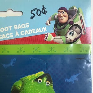 Puede incluir: Un paquete de bolsas de regalo con Buzz Lightyear de Toy Story en la tarjeta de cabecera con el texto LOOT BAGS y SACS &Agrave; CADEAUX. El empaque incluye un dise&ntilde;o en verde y azul con un gr&aacute;fico de personaje verde y peque&ntilde;as siluetas azules.