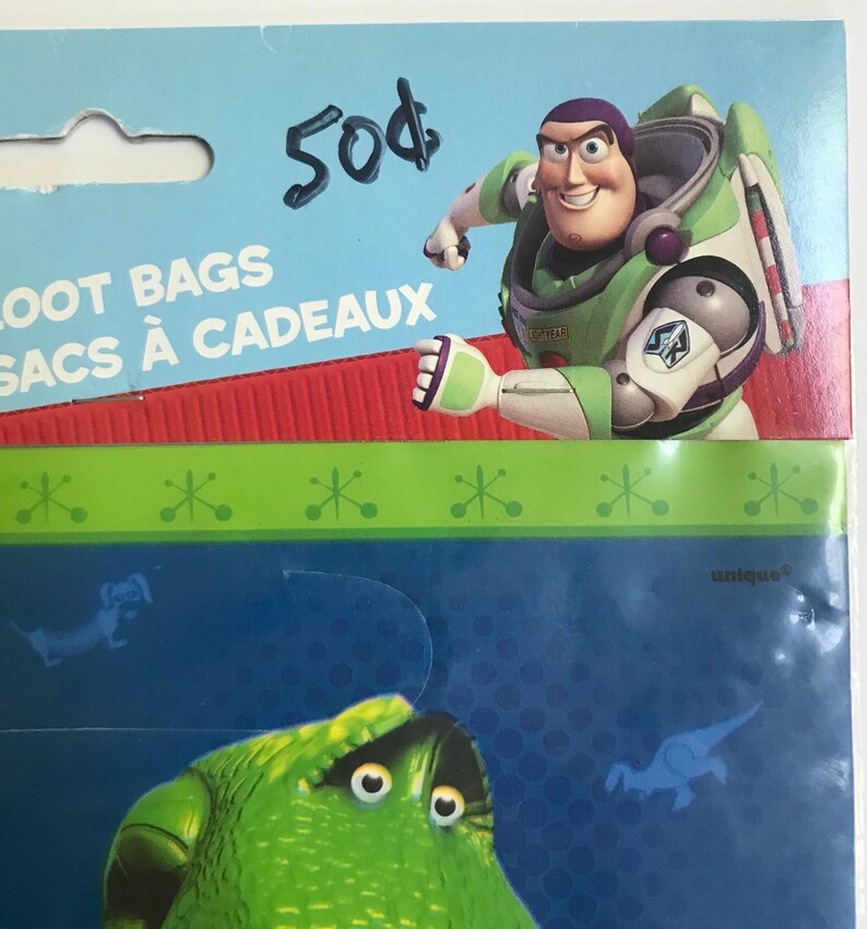 Puede incluir: Un paquete de bolsas de regalo con Buzz Lightyear de Toy Story en la tarjeta de cabecera con el texto LOOT BAGS y SACS &Agrave; CADEAUX. El empaque incluye un dise&ntilde;o en verde y azul con un gr&aacute;fico de personaje verde y peque&ntilde;as siluetas azules.
