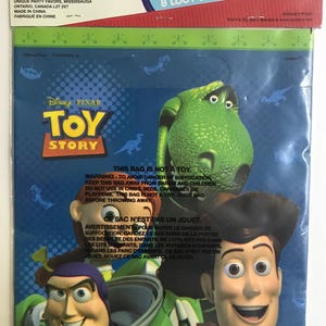 Puede incluir: Un paquete de 8 bolsas de regalo de pl&aacute;stico azul con personajes de Toy Story de Disney Pixar, incluyendo a Woody, Buzz Lightyear, Jessie y Rex. El frente de la bolsa muestra el logotipo de Toy Story y advertencias de seguridad en ingl&eacute;s y franc&eacute;s.