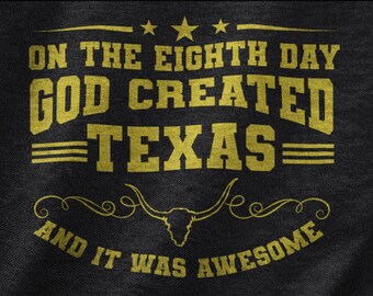 May include: A black t-shirt with gold text that reads "On the eighth day God created Texas and it was awesome".