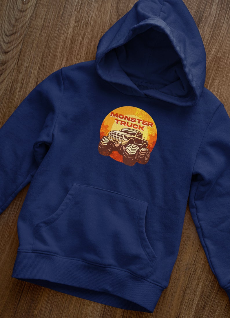 Puede incluir: Una sudadera con capucha azul marino con un bolsillo en la parte delantera. La sudadera tiene un gr&aacute;fico de un cami&oacute;n monstruo con el texto "Monster Truck" en un c&iacute;rculo.