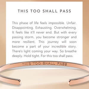 May include: Rose gold bangle bracelet with the inscription "This too shall pass".