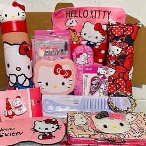 May include: A collection of Hello Kitty themed items including a water bottle with a character cap, a pink towel, a makeup brush set, a pink compact mirror, correction tape, a comb, a beaded bracelet, a sleep mask, and a patterned wallet.