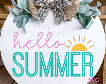 May include: A white round wooden sign with a burlap bow and greenery. The sign says "hello summer" in pink script with a teal sun and rays.