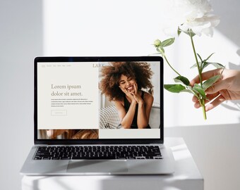 May include: A laptop computer with a white background and a website open on the screen. The website has the text "Lark" in the top right corner and the text "Lorem ipsum dolor sit amet." in the center of the screen. A woman with curly brown hair is smiling in the bottom right corner of the screen.