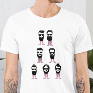 May include: White t-shirt featuring a graphic of stylized beards with legs. The beards are black with various styles, and the legs are pink. The shirt is a short-sleeved crew neck.