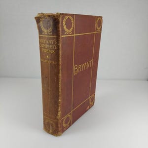 May include: A vintage hardcover book titled "Bryant's Complete Poems, Illustrated." The book has a brown cover with gold lettering and decorative elements. The spine is worn, and the book appears to be antique.