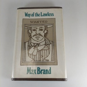 May include: A vintage paperback book cover with a brown background and a gold illustration of a man with a mustache wearing a hat. The text on the cover reads "Way of the Lawless" and "WANTED" in a gold font. The author's name, "Max Brand", is printed in green at the bottom of the cover.