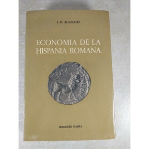 May include: A yellow book with the title "Economia de la Hispania Romana" by J. M. Blazquez. The book cover features a silver coin with a bull on it.